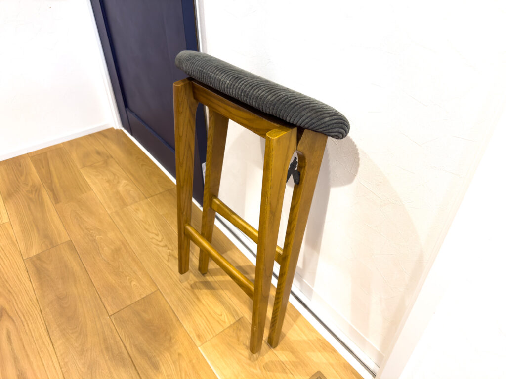 折りたたんで壁に立てかけたハイスツール。薄くなり壁際のすき間に収まる