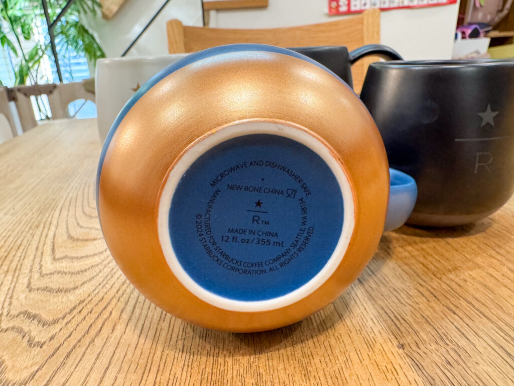 青いスターバックス リザーブ マグカップの裏側。カッパー色の底に、NEW BONE CHINAや12 fl oz/355mLの刻印がある
